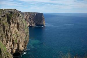 Seaside Majesty Breathtaking Coastal Cliffs Meet Stunning Blue Sea, A Spectacle of Nature's Grandeur photo