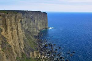 Seaside Majesty Breathtaking Coastal Cliffs Meet Stunning Blue Sea, A Spectacle of Nature's Grandeur photo