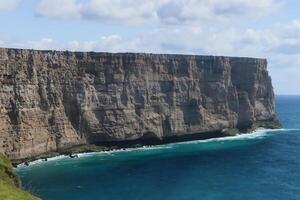 Seaside Majesty Breathtaking Coastal Cliffs Meet Stunning Blue Sea, A Spectacle of Nature's Grandeur photo