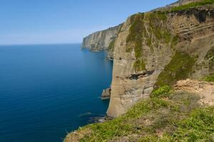 Seaside Majesty Breathtaking Coastal Cliffs Meet Stunning Blue Sea, A Spectacle of Nature's Grandeur photo