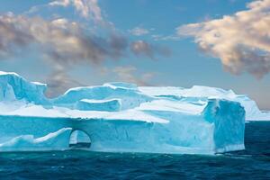 Majestic Ice Cliffs Crowned by a Cool Atmosphere, Framed by the Beautiful Sea and Sky, Conjuring a Harmonious Panorama of Nature's Icy Grandeur and Oceanic Splendor photo