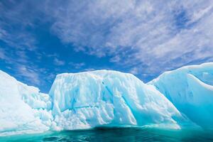 majestuoso hielo acantilados coronado por un frio atmósfera, enmarcado por el hermosa mar y cielo, prestidigitación un armonioso panorama de de la naturaleza glacial grandeza y oceánico esplendor foto