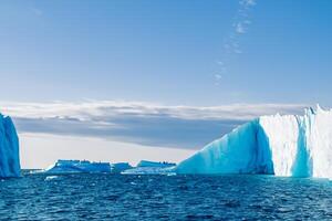 Majestic Ice Cliffs Crowned by a Cool Atmosphere, Framed by the Beautiful Sea and Sky, Conjuring a Harmonious Panorama of Nature's Icy Grandeur and Oceanic Splendor photo