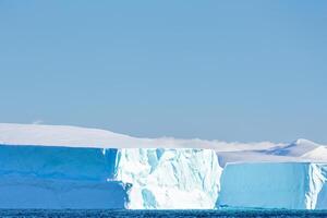 Majestic Ice Cliffs Crowned by a Cool Atmosphere, Framed by the Beautiful Sea and Sky, Conjuring a Harmonious Panorama of Nature's Icy Grandeur and Oceanic Splendor photo