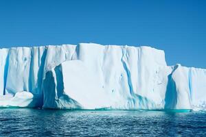 majestuoso hielo acantilados coronado por un frio atmósfera, enmarcado por el hermosa mar y cielo, prestidigitación un armonioso panorama de de la naturaleza glacial grandeza y oceánico esplendor foto