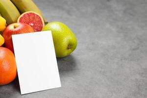 Card and White Paper Mockup Harmonized with Fresh Fruit, Crafting a Visual Symphony of Artful Design and Culinary Delight, Where Wholesome Ingredients Merge in a Feast of Vibrant Imagery photo