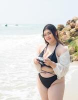 retrato joven asiático mujer grasa gordito linda hermosa sonrisa contento divertido disfrutar relajarse bikini trajes de baño cuerpo sexy frente ver mar playa blanco arena limpiar cielo azul calma naturaleza Oceano ola agua viaje en fiesta foto