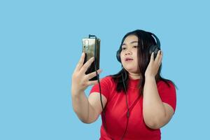 retrato negocio niña joven mujer asiático gordito grasa linda hermosa bonito uno persona vistiendo rojo camisa en oficina participación digital tableta y sonriente en pie con Copiar espacio en aislado azul suelo negro foto