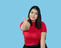 Portrait girl young woman asian chubby fat cute beautiful pretty one person wearing a red shirt is sitting smiling enjoy happily looking wow to copyspace imaginary on the blue background photo