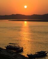 puesta de sol a ayeyarwady río en bagan, myanmar foto