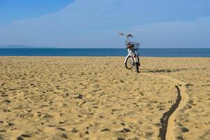 bicicleta en playa con azul cielo y mar en antecedentes. vacaciones y recreación concepto. foto