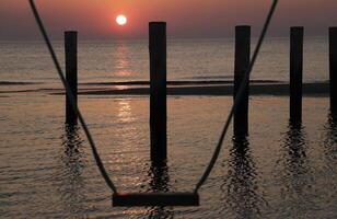 sunset, swing set, pole village in the netherlands photo