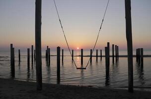 sunset, swing set, pole village in the netherlands photo