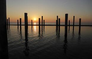 puesta de sol en el polo pueblo de petten en el Países Bajos foto