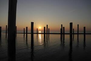 puesta de sol en el polo pueblo de petten en el Países Bajos foto