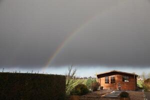 oscuro cielo en paisaje con arco iris foto