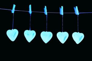 five hearts hang from a line with pegs photo