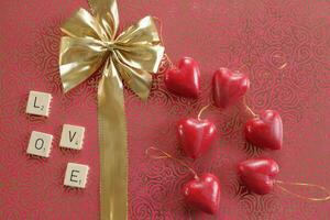 bow in a gold ribbon on a red background, valentines day wishes photo