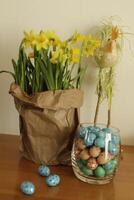 paper bag with daffodils and easter eggs photo