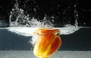 splashing bellpepper in water photo