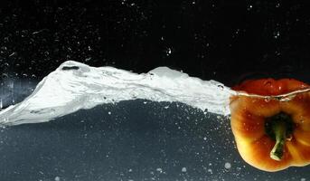 splashing bellpepper in water photo