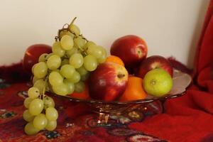 Fruta cuenco con uvas, manzanas, naranjas foto