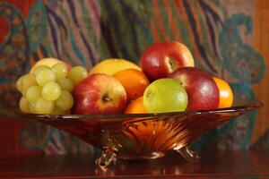 Fruta cuenco con uvas, manzanas, naranjas foto