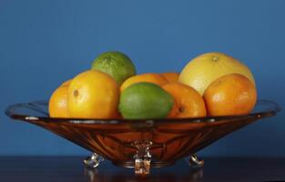 a glass bowl with citrus fruit photo