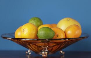 a glass bowl with citrus fruit photo