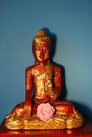 sitting Buddha statue with pink rose photo