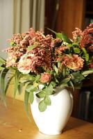 a white vase with a bouquet salmon color flowers photo