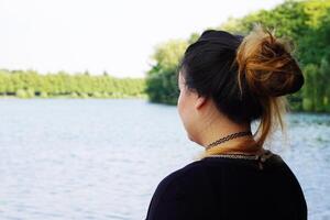 joven mujer mirando terminado lago foto