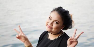 young asian woman making V hand sign photo