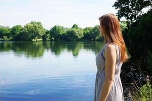 young woman looking at idyllic lake photo