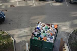 garbage containers with waste on the street photo