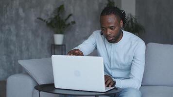 online Lernen, afrikanisch amerikanisch Student, Entfernung Lektion, Bildung beim heim, Webinar Konferenz. männlich afrikanisch amerikanisch Schüler wendet sich auf Laptop und beginnt online Ausbildung. video