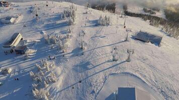 Snow-covered ski resort winter wonderland breathtaking aerial view. Ski resort perfect for cold-weather fun snowy slopes. Ski resort surrounded by serene winter forest snowy escape tranquil serene. video