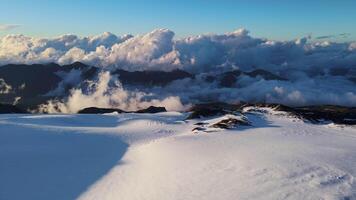 a snowy mountain covered in clouds with a blue sky in the background video