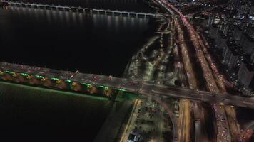 encima Seúl noche tráfico de la ciudad latido del corazón en luminoso fluir Seúl noche tráfico debajo oscuro cielo espejos dinámica urbano espíritu. noche en Seúl iluminado por interminable corrientes de tráfico. video