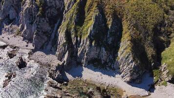 Bedrock outcrop by the ocean, with trees on rocky cliff video