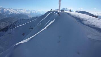 Aerial. the skier begins to descend from the ridge along an unprepared slope video