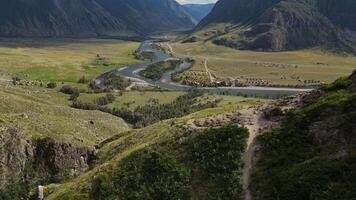 antenne visie van de mooi vallei en rivier- omringd door hoog berg bereiken video