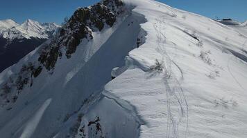 antenne. berg reeks met sneeuw slagen en ski merken video