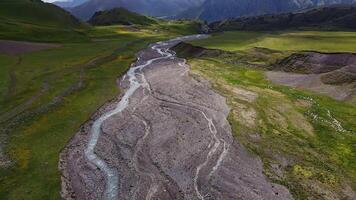 Aerial view of a mountain river valley among green meadows video