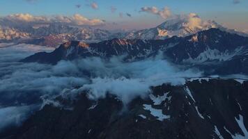 Enticing snowy mountains rising touch cloud filled skies drone view Journey through enticing snowy mountains experience Earth's rugged grace. Nature's masterpiece enticing snowy mountains. video