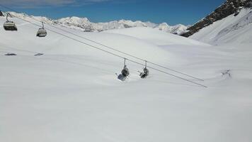 Aerial. a chairlift in the mountains covered with snow. video