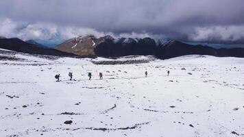 Aerial view of a group of climbers walking with backpacks along a path video