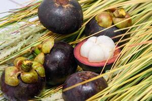 Queen of fruit. Mangosteens and knife on the grass. photo