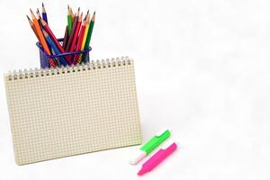 Crayon or colored pencils in box and graph book on white background. Learning, study and presentation concept. photo