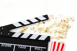 Clapperboard or movie slate black color with popcorn on white background. Cinema industry, production and film concept. photo